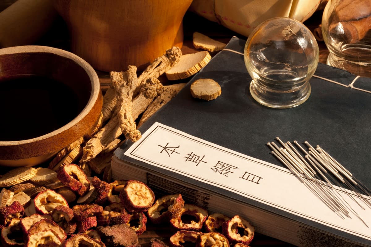 Chinesische Kräuter und Akupunkturnadeln auf einem Tisch