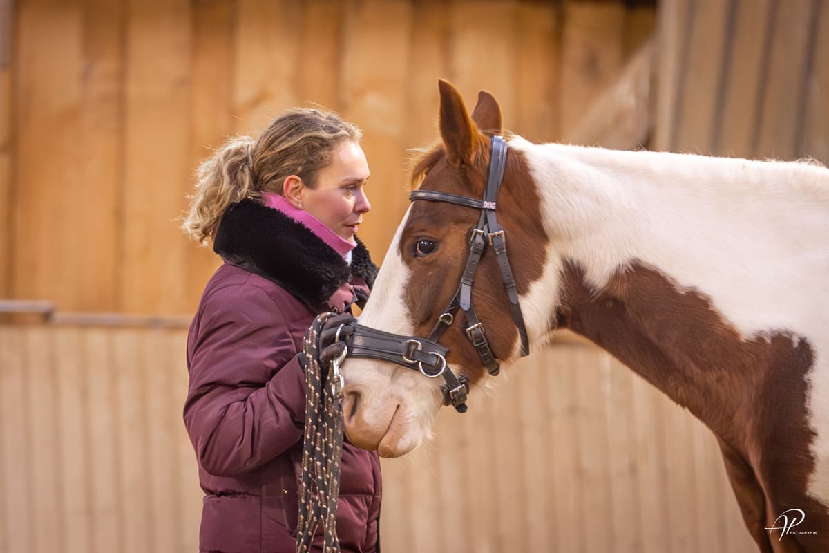 Alina Arold steht Kopf an Kopf mit einem Pferd